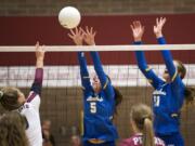 Prairie’s Maddi Cederholm (9) spikes the ball as Kelso’s Sydney Hall (5) and Isabella Hadaller (11) jump to block during Tuesday night’s game at Prairie High School in Camas on Sept. 25, 2018. Prairie won in three sets, 25-10, 25-13, 25-13.