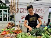 Kelly Peters of Flat Tack Farm works at her Vancouver Farmers Market booth.