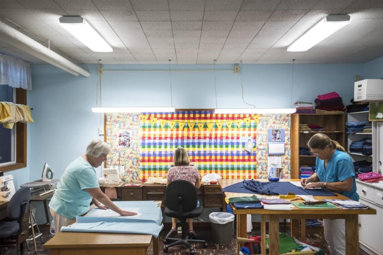 Sandy Hubbard, left, Shaune Kelly, and Julie Love are among the volunteers in the Helping Hands Sewing Group at St. Luke’s ~ San Lucas Episcopal Church in Vancouver. The group sews clothing for homeless children every Thursday.