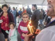 Chena Johnson, from left, Emelya Johnson, 4, and Jazlyn Johnson, 9, react to a magic trick performed by Adam the Great while waiting in line for the free pancake breakfast at the Clark County Fair on Friday morning, Aug. 2, 2019.  Adam the Great will perform on The Columbian stage on Monday at 2 pm.