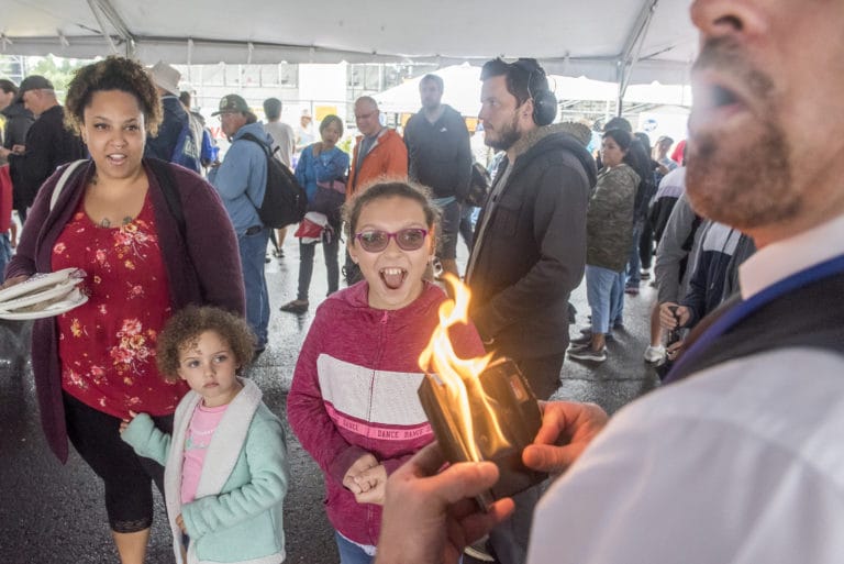 Chena Johnson, from left, Emelya Johnson, 4, and Jazlyn Johnson, 9, react to a magic trick performed by Adam the Great while waiting in line for the free pancake breakfast at the Clark County Fair on Friday morning, Aug. 2, 2019.  Adam the Great will perform on The Columbian stage on Monday at 2 pm.