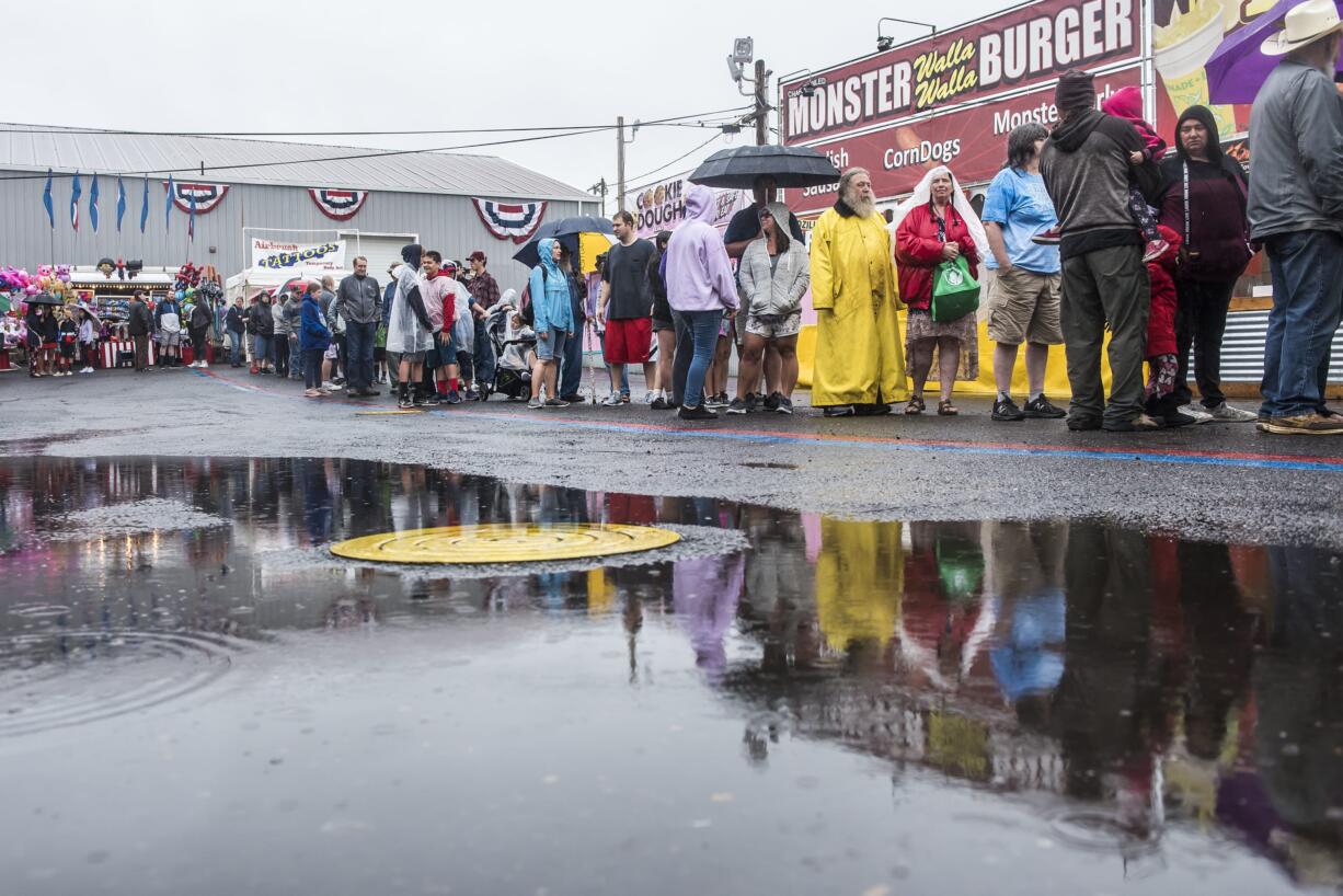 A crowd waits in the rain for the start of the free pancake breakfast at the Clark County Fair on Friday morning, Aug. 2, 2019.