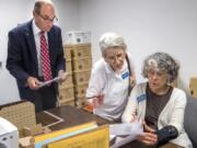 Clark County Auditor Greg Kimsey and observers Karen Hengerer and Edri Geiger, with the League of Women Voters, view the first primary election result printouts in the Clark County Elections office on Tuesday night.