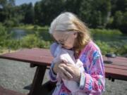 MaryAnn St. Mars affectionately holds her doll outside her home in Woodland. St. Mars recently received the doll as part of the Hope Dementia Support Group program, which provides dolls and stuffed animals to help calm those with dementia.