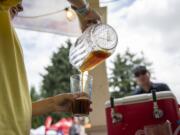 Volunteer Alicia Campbell of La Center pours a glass of beer at Vancouver Brewfest in Esther Short Park on Saturday afternoon, August 10, 2019.