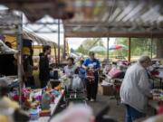 Shoppers and volunteers mingle under a pavilion during Fourth Plain Church of the Nazarene’s sixth annual Care 2 Share event where items are given away free to the community.