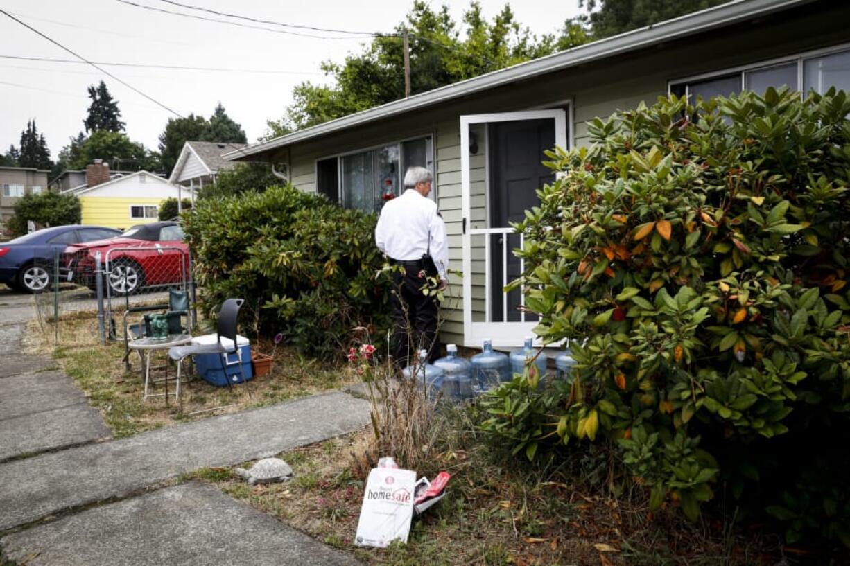 Vancouver Deputy Fire Marshal Skip Navarrette goes door to door to hand out fire prevention education materials as a part of Project Home Safe in Vancouver on Aug. 10.