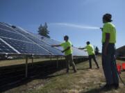 Rafer Stromme, from left, Nick Neathamer and Spencer Black, members of the student grounds crew, clean solar panels at Clark Public Utilities’ operations center in Vancouver. In 2015, Clark Public Utilities launched a program that prompted about 700 customers to invest in the county’s largest solar array. The solar panels need to be cleaned to remove dust to maximize energy production, especially in the summer months.