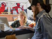 Ali Cohen, left, is assisted by Jim Rowe of Slow Fox Chili Parlor as she completes her lunch order at the Columbia Food Park on Tuesday afternoon.