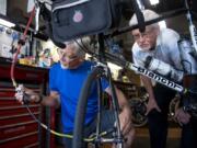 Brothers Mark Roskam, left, and Mike Roskam perform maintenance on Mark’s bike at Wheel Deals Bicycles on Monday. The two plan to ride Route 66 starting next month for a fundraiser.