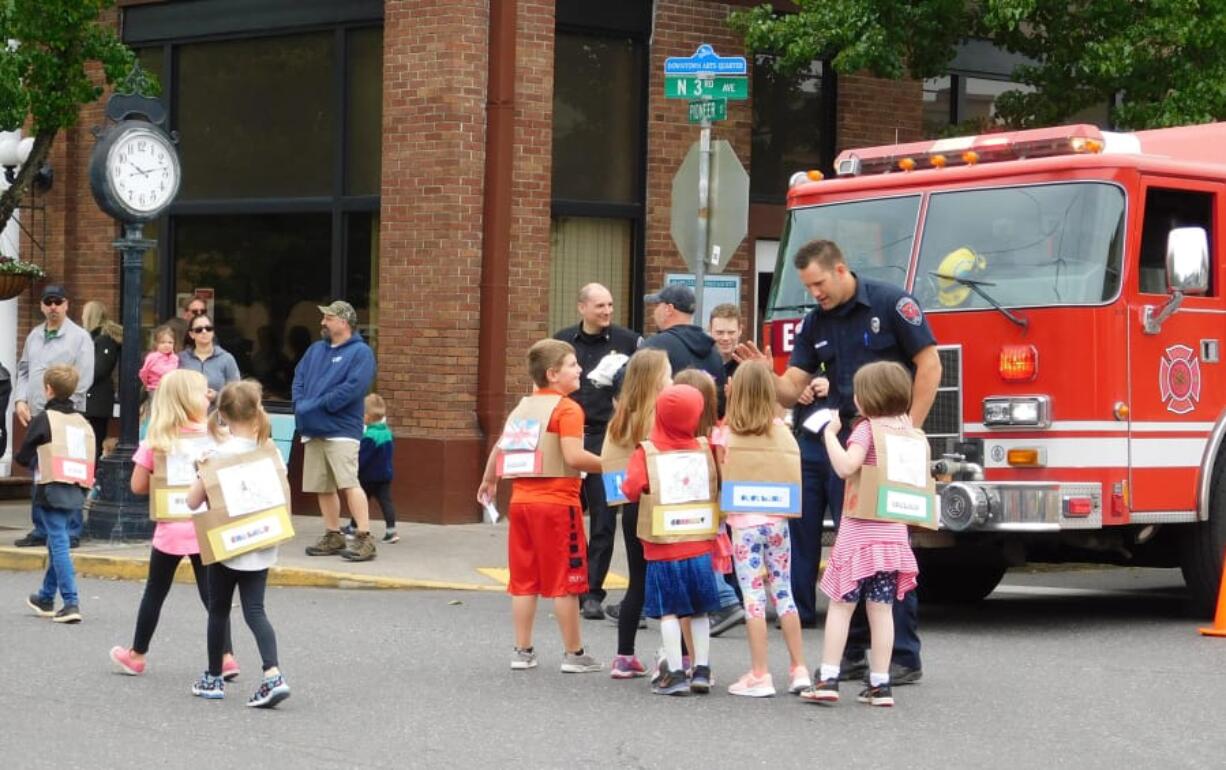 RIDGEFIELD: A firefighter high-fives Union Ridge Elementary School students as they walk the parade route at the school’s annual Culture Parade.