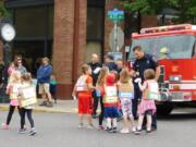 RIDGEFIELD: A firefighter high-fives Union Ridge Elementary School students as they walk the parade route at the school’s annual Culture Parade.