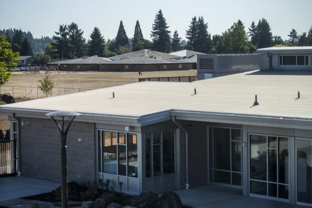 The former Peter S. Ogden Elementary School, background, which now temporarily houses Martin Luther King Elementary School, is seen here behind a portion of the new building. Students start their first day at the new school on Tuesday. Ogden Elementary is the first school to open under the district’s $458 million bond-funded construction campaign.