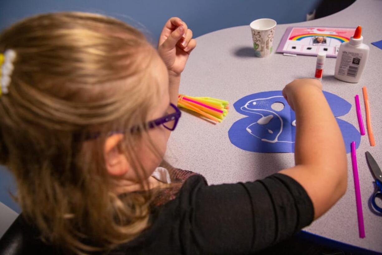 Sonja Cowell works on an art project at the Center for Autism and Related Disorders, or CARD, on Saturday afternoon. CARD offers resources and therapy to help families and adults navigate autism.