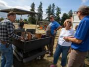 Marcella Schurman, second from right, talks with Aumann Auctions staff after finding an engine her late husband Alan built by hand, at her property in Ridgefield on Saturday.