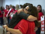 La Center graduate Andrea Lewis, right, embraces La Center English teacher Karen Gozart as the teachers lined up before a morning bargaining session with the district at La Center High School on Aug. 20.