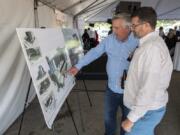 Rob Gartner, vice president of business development for Vesta Hospitality, left, describes the future AC Hotel layout to David Partridge of Vancouver during the ceremonial groundbreaking on Thursday afternoon. At top, a concept art rendering shows the future AC Hotel by Marriott, which broke ground today at Terminal 1.