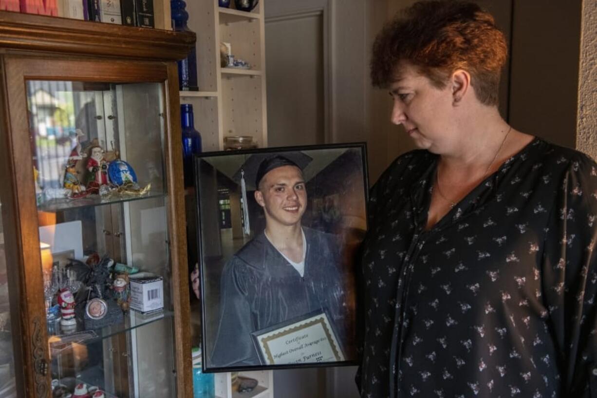 Lyn Anderson, co-founder of the local Overdose Awareness Day event, looks at a picture of her late son, Ryan Furness, who died on Aug. 19, 2012, from a heroin overdose. The photo shows Furness receiving a certificate of achievement for having the highest math average of his class at the ESD 112 GED program through Clark County’s Juvenile Justice Department.