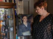 Lyn Anderson, co-founder of the local Overdose Awareness Day event, looks at a picture of her late son, Ryan Furness, who died on Aug. 19, 2012, from a heroin overdose. The photo shows Furness receiving a certificate of achievement for having the highest math average of his class at the ESD 112 GED program through Clark County’s Juvenile Justice Department.