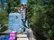 One of several mock train robbers boards a diesel train on the Chelatchie Prairie Railroad on Sunday in Yacolt.