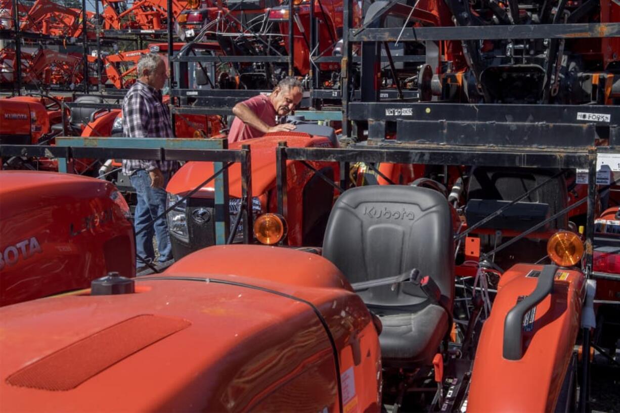 Don Suetta, left, and his brother John Suetta, both of Woodland, examine tractors on display at Dan’s Tractor. Owner Skip Ogden said he was worried about having to start charging sales tax for Oregonians, but then he learned he could still avoid the tax by delivering orders to Oregon customers.