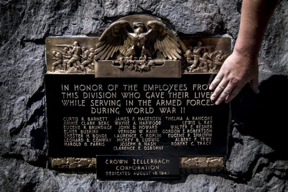 Ryan Hickey, operations specialist with the city of Camas, shows where damage had previously been located on a memorial for Camas mill workers who died serving in World War II.