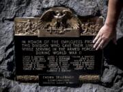 Ryan Hickey, operations specialist with the city of Camas, shows where damage had previously been located on a memorial for Camas mill workers who died serving in World War II.