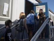 Maria Garcia, fifth-grade dual-language immersion teacher, greets her students on the first day of class at Pioneer Elementary School on Tuesday. Garcia is a first-year teacher at the school after graduating this year from a Washington State University teaching program designed for bilingual paraeducators.