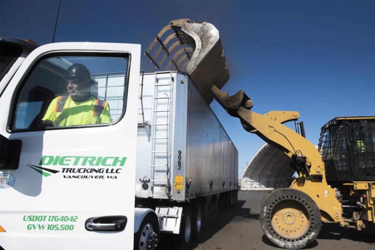 Louis Ruiz, a driver with Dietrich Trucking, climbs into the cab of his truck while a loader drops yard debris into his trailer at the West Vancouver Materials Recovery Center on Wednesday afternoon. Waste Connections currently layers yard debris above and below food waste before it is trucked to a composting facility in Dallesport.