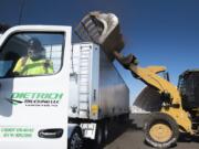 Louis Ruiz, a driver with Dietrich Trucking, climbs into the cab of his truck while a loader drops yard debris into his trailer at the West Vancouver Materials Recovery Center on Wednesday afternoon. Waste Connections currently layers yard debris above and below food waste before it is trucked to a composting facility in Dallesport.