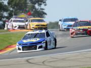 Chase Elliott leads the field thought the area known as "The Bus Stop" during a NASCAR Cup Series auto race at Watkins Glen International, Sunday, Aug. 4, 2019, in Watkins Glen, N.Y.