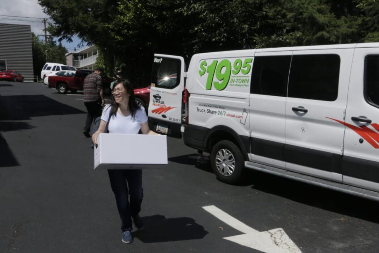 Linda Yang, with the ‘Let People Vote’ campaign, carries a box of signed petitions for Referendum 88, on Wednesday, July 24, 2019, in Olympia, Wash. Proponents of the referendum are opposed to an affirmative action measure approved by the Legislature earlier this year that permits state agencies to establish diversity goals and timelines, and consider membership in a minority group as a contributing factor for an applicant.