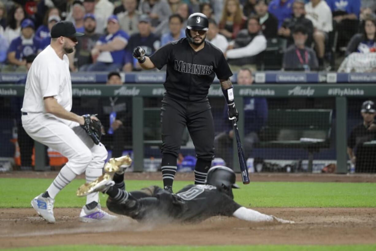 Seattle Mariners’ Omar Narvaez, right, watches as Mallex Smith scores on a wild pitch by Toronto Blue Jays’ Tim Mayza, left, during the sixth inning of a baseball game Friday, Aug. 23, 2019, in Seattle. (AP Photo/Ted S.