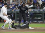 Seattle Mariners’ Omar Narvaez, right, watches as Mallex Smith scores on a wild pitch by Toronto Blue Jays’ Tim Mayza, left, during the sixth inning of a baseball game Friday, Aug. 23, 2019, in Seattle. (AP Photo/Ted S.