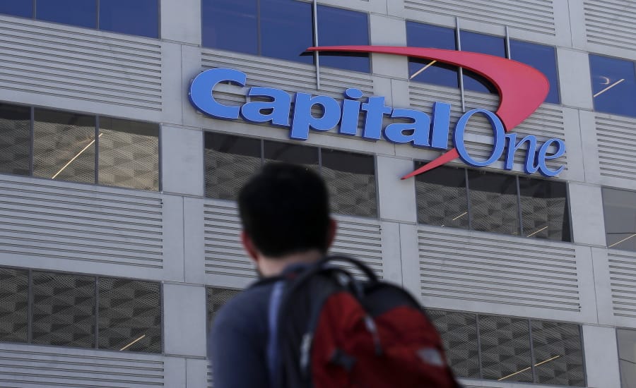 A man walks across the street from a Capital One location in San Francisco. Federal prosecutors say Paige Thompson, the woman accused of hacking Capital One and at least 30 other organizations, is a threat to herself and society, a flight risk and should be kept locked up until her trial.