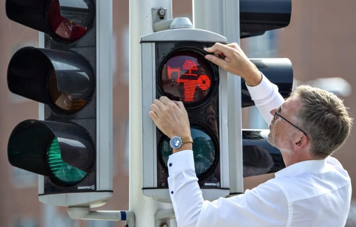 Director of Moesgaard Museum Mads Kähler Holst replaces the first of many pedestrian signals for Viking signals in Aarhus, Denmark, Monday, Aug. 26, 2019. The red and green Viking inspired signs have been chosen to symbolise Aarhus’s special Viking history.