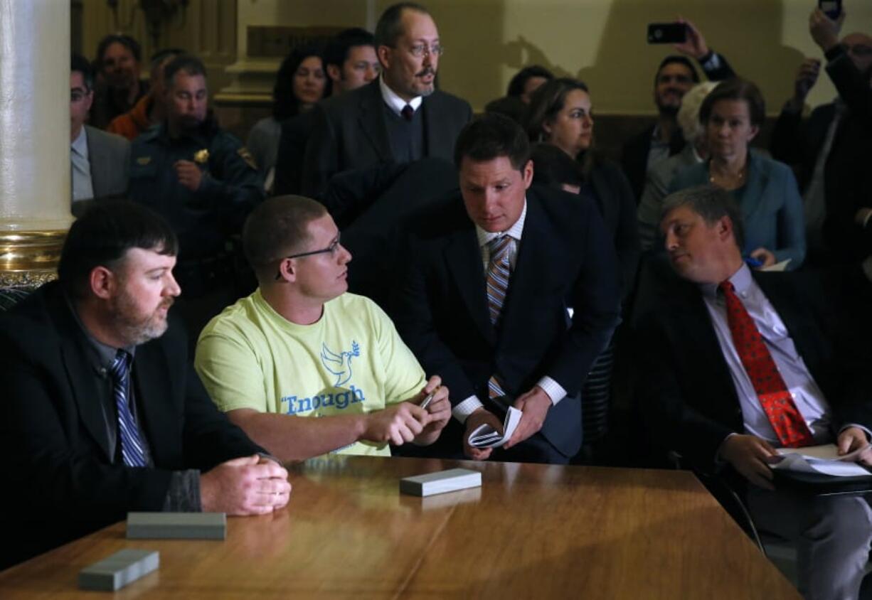 FILE - In this Dec. 19, 2016, file photo, Colorado elector Micheal Baca, second from left, talks with legal counsel after he was removed from the panel for voting for a different candidate than the one who won the popular vote, during the Electoral College vote at the Capitol in Denver. Colorado Secretary of State Wayne Williams, front right, looks on. On Tuesday, Aug. 20, 2019, the 10th U.S. Circuit Court of Appeals ruled that Williams violated the Constitution when he removed Baca from the panel.