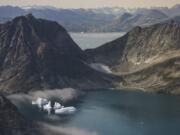 In this photo taken on Wednesday, Aug. 14, 2019, icebergs are photographed from the window of an airplane carrying NASA Scientists as they fly on a mission to track melting ice in eastern Greenland. Greenland has been melting faster in the last decade and this summer, it has seen two of the biggest melts on record since 2012.