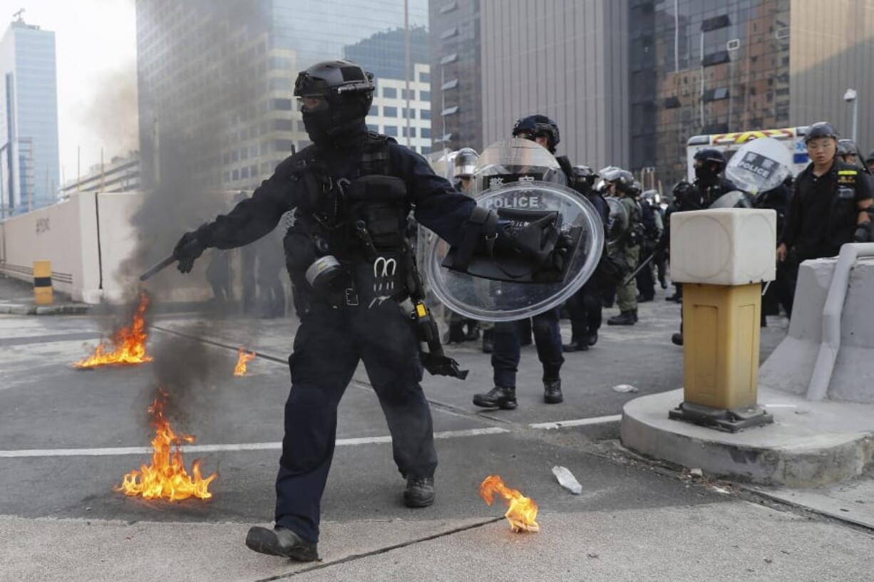 Riot police move small fires during a protest in Hong Kong, Saturday, Aug. 24, 2019. Chinese police said Saturday they released an employee at the British Consulate in Hong Kong as the city’s pro-democracy protesters took to the streets again, this time to call for the removal of “smart lampposts” that raised fears of stepped-up surveillance.