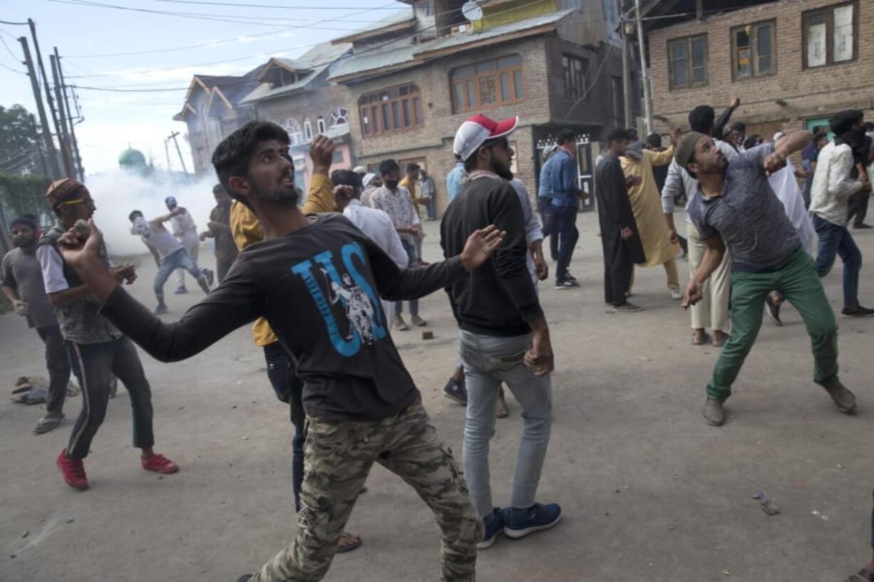 Kashmiris throw stones at security personnel during a protest in Srinagar Indian controlled Kashmir, Friday, Aug. 23, 2019. Authorities intensified patrols Friday in Indian-controlled Kashmir’s main city after posters appeared calling for a public march to a United Nations office to protest New Delhi’s tightened grip on the disputed region.