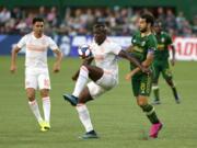 Atlanta United's Florentin Pogba, center, controls the ball as teammate Gonzalo "Pity" Martínez, left, looks on and Portland Timbers' Diego Valeri attempts to maneuver around him during an MLS soccer match host in Portland, Ore., on Sunday, Aug. 18, 2019.