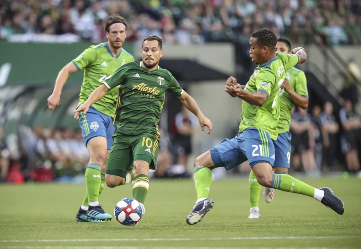 Portland Timbers’ Sebastian Blanco works between Seattle Sounders, including Jordy Delem (21), during the first half of an MLS soccer match Friday, Aug. 23, 2019, in Portland, Ore.