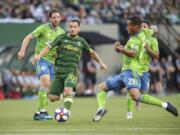 Portland Timbers’ Sebastian Blanco works between Seattle Sounders, including Jordy Delem (21), during the first half of an MLS soccer match Friday, Aug. 23, 2019, in Portland, Ore.