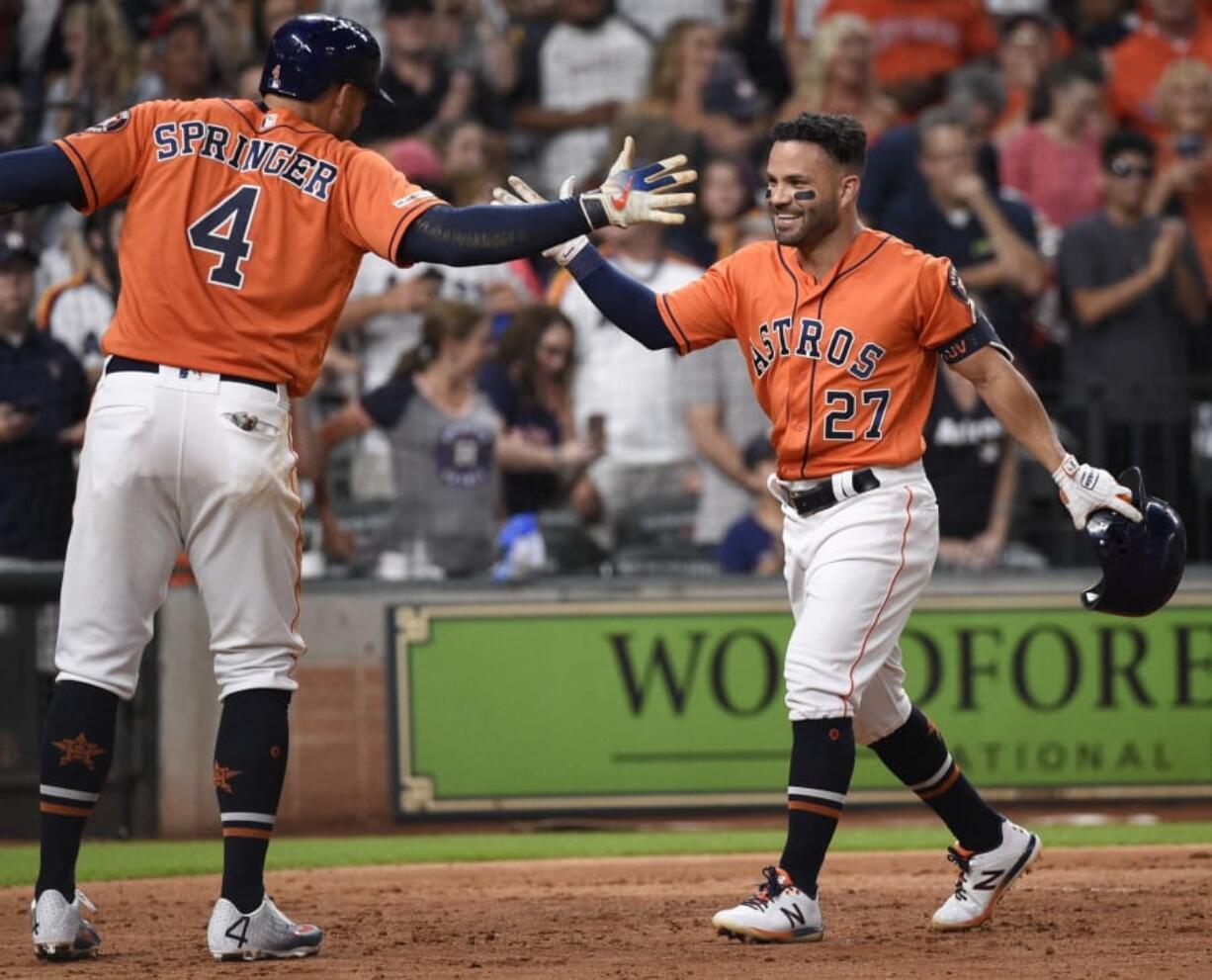 Houston Astros’ Jose Altuve (27) celebrates his solo home run off Seattle Mariners starting pitcher Yusei Kikuchi with George Springer during the fourth inning of a baseball game Friday, Aug. 2, 2019, in Houston.