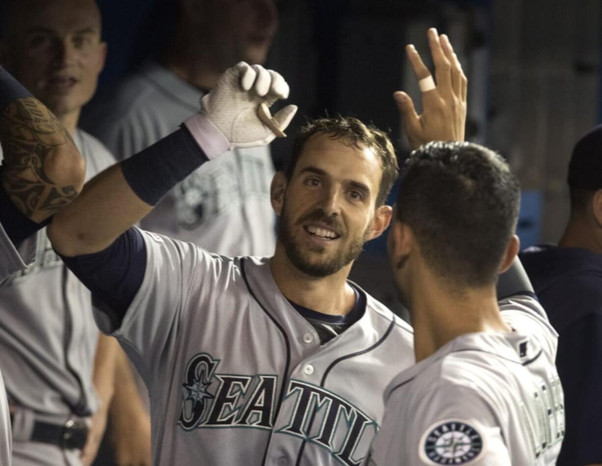 Seattle Mariners’ Austin Nola celebrates in the dugout with teammates after hitting a solo home run during fourth-inning baseball game action against the Toronto Blue Jays in Toronto, Saturday, Aug. 17, 2019.