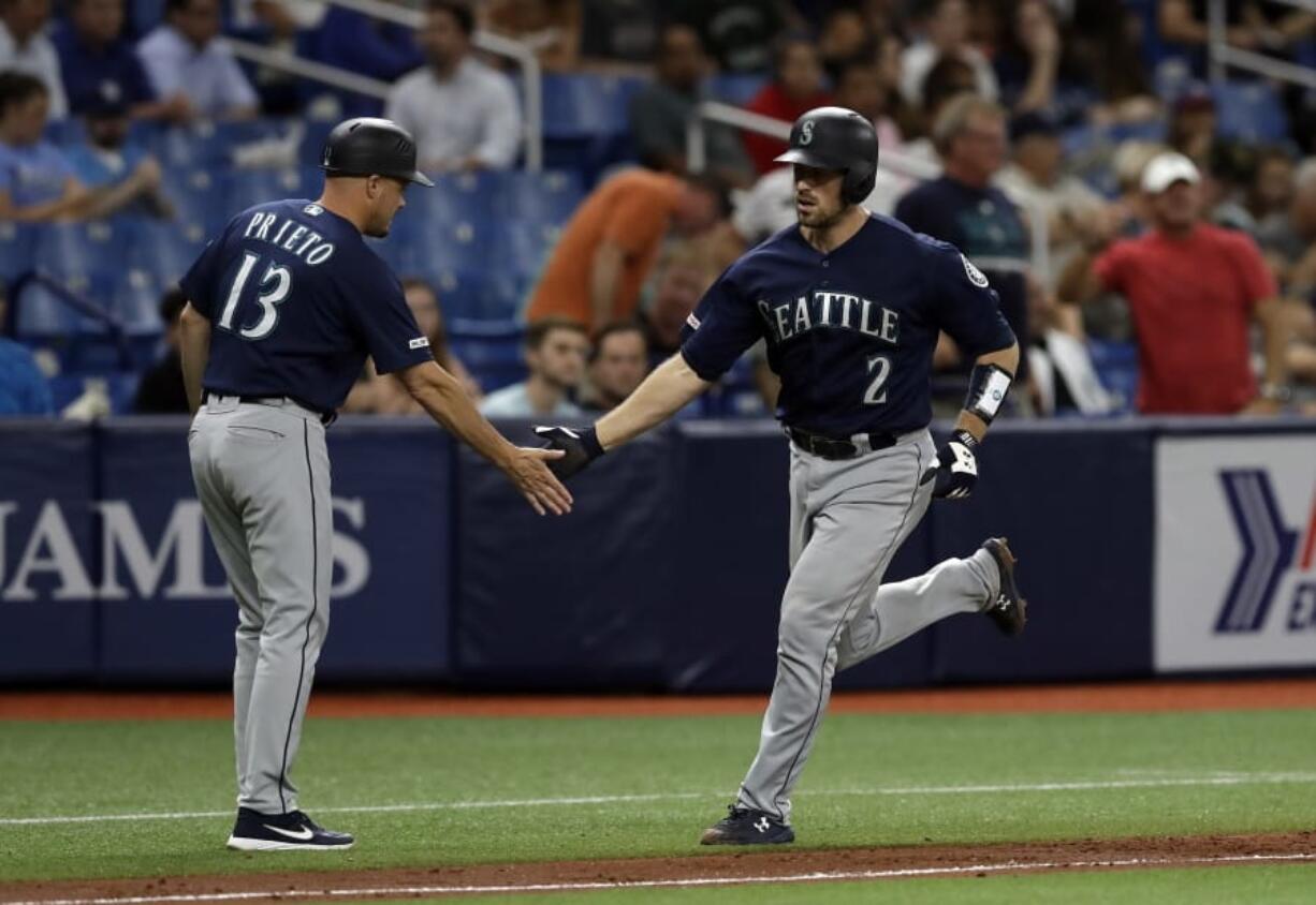 Seattle Mariners’ Tom Murphy (2) shakes hands with third base coach Chris Prieto (13) after Murphy hit a two-run home run off Tampa Bay Rays relief pitcher Jalen Beeks during the sixth inning of a baseball game Tuesday, Aug. 20, 2019, in St. Petersburg, Fla.