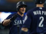 Seattle Mariners' Kyle Seager is greeted at the dugout by teammate Tom Murphy after a three-run home run during the sixth inning of a baseball game against the Detroit Tigers, Tuesday, Aug. 13, 2019, in Detroit.