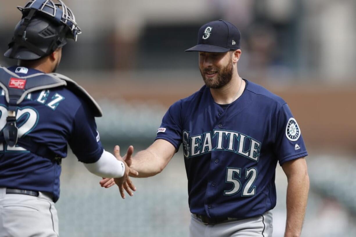 Seattle Mariners relief pitcher Anthony Bass (52) shakes hands with catcher Omar Narvaez after the Mariners’ 7-2 win over the Detroit Tigers in a baseball game, Thursday, Aug. 15, 2019, in Detroit.