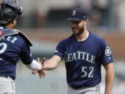 Seattle Mariners relief pitcher Anthony Bass (52) shakes hands with catcher Omar Narvaez after the Mariners’ 7-2 win over the Detroit Tigers in a baseball game, Thursday, Aug. 15, 2019, in Detroit.