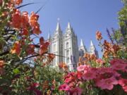 FILE - This Aug. 4, 2015 file photo, flowers bloom in front of the Salt Lake Temple, at Temple Square, in Salt Lake City. The Church of Jesus Christ of Latter-day Saints is reminding members that coffee is prohibited no matter how fancy the name, that vaping is banned despite the alluring flavors and that marijuana is outlawed unless prescribed by a competent doctor.